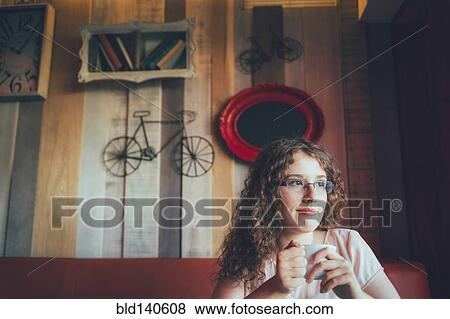 Stock Photo - Woman drinking cup of coffee in cafe. Fotosearch