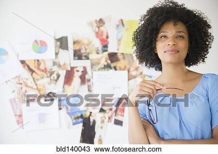 Woman holding eyeglasses near wall with photographs View Large Photo Image Stock Image - Woman holding eyeglasses near wall with photographs. Fotosearch