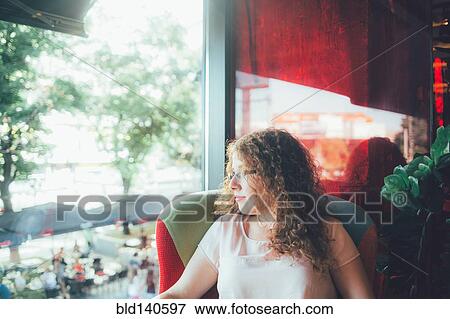 Stock Photo - Woman relaxing in chair near window. Fotosearch