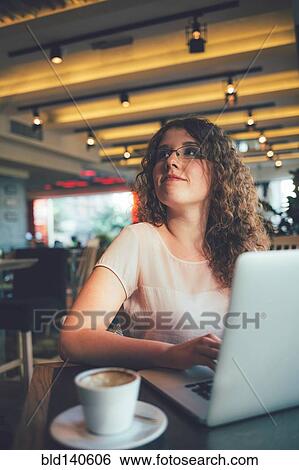 Stock Photograph - Woman using laptop computer in cafe. Fotosearch
