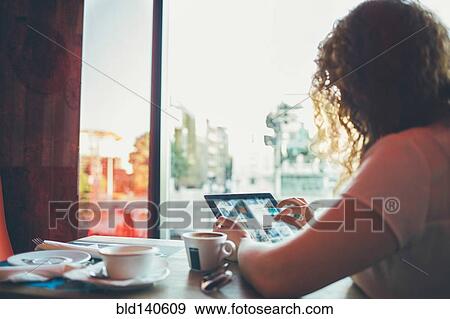 Woman using tablet computer in cafe View Large Photo Image Stock Photo - Woman using tablet computer in cafe. Fotosearch