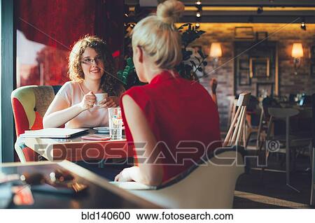 Stock Image - Women drinking coffee in cafe. Fotosearch