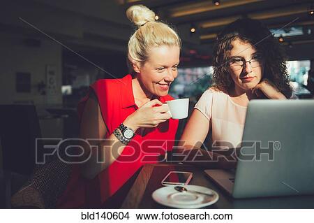 Picture - Women using laptop computer in cafe. Fotosearch