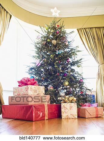 Stock Photo - Wrapped gifts under Christmas tree. Fotosearch