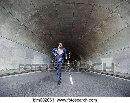 Black businessman running with briefcase in urban tunnel View Large Photo Image Stock Image - Black businessman running with briefcase in urban tunnel. Fotosearch
