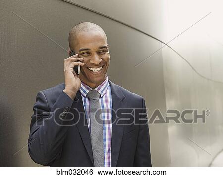 Stock Photograph - Black businessman talking on cell phone. Fotosearch