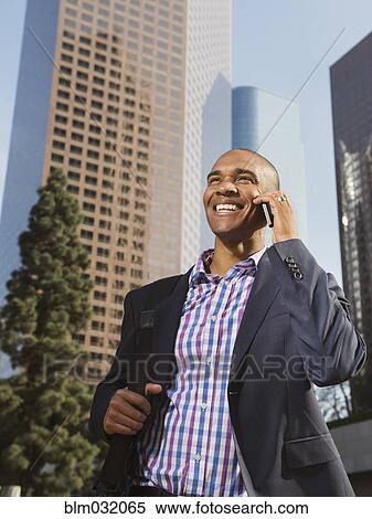 Black businessman talking on cell phone in city View Large Photo Image Stock Photography - Black businessman talking on cell phone in city. Fotosearch