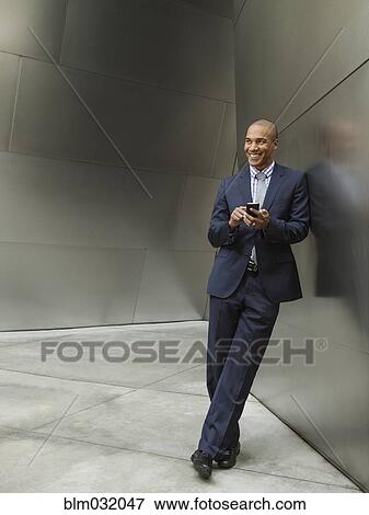 Stock Photo - Black businessman using cell phone. Fotosearch