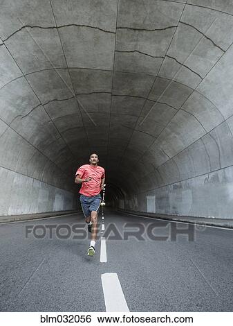 Stock Photograph - Black man running in urban tunnel. Fotosearch
