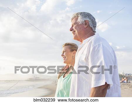 Stock Photo - Caucasian couple hugging on beach. Fotosearch