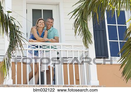 Stock Image - Caucasian couple standing on balcony. Fotosearch