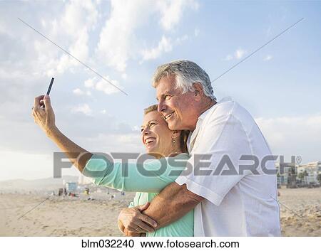 Caucasian couple taking cell phone selfie on beach View Large Photo Image Stock Image - Caucasian couple taking cell phone selfie on beach. Fotosearch