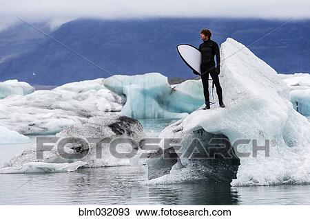 Caucasian surfer carrying board near glacial water View Large Photo Image Stock Image - Caucasian surfer carrying board near glacial water. Fotosearch