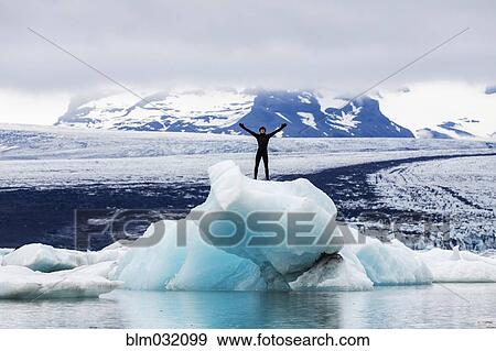 Caucasian surfer standing with arms outstretched near glacial water View Large Photo Image Stock Photo - Caucasian surfer standing with arms outstretched near glacial water. Fotosearch