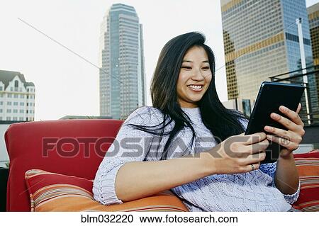 Chinese woman using digital tablet on urban rooftop View Large Photo Image Stock Image - Chinese woman using digital tablet on urban rooftop. Fotosearch