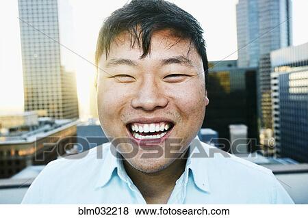 Korean man smiling on urban rooftop View Large Photo Image Stock Photo - Korean man smiling on urban rooftop. Fotosearch