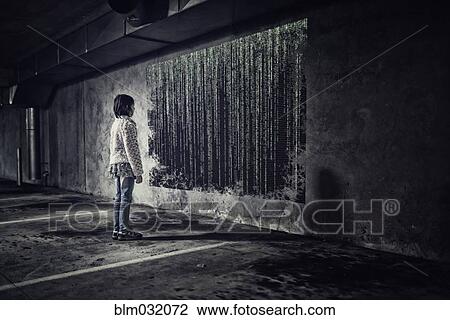 Stock Image - Mixed race girl examining binary code on screen in parking lot. Fotosearch