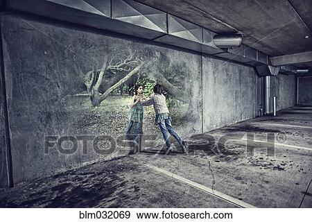 Stock Photo - Mixed race girl in parking lot playing with reflection in forest. Fotosearch
