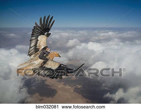 Stock Image - Woman riding eagle flying over clouds in sky. Fotosearch