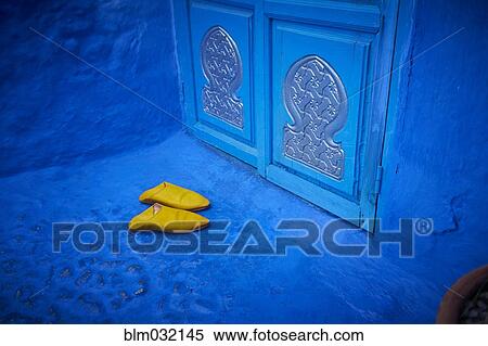 Stock Photography - Yellow shoes near ornate blue doorway, Chefchaouen, Chefchaouen, Morocco. Fotosearch