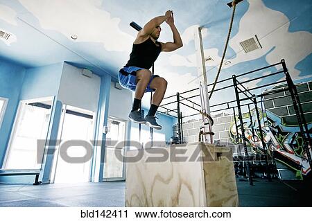 Stock Image - African American man exercising in gym. Fotosearch