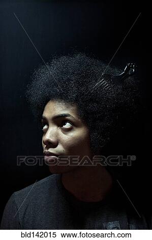 Stock Photography - African American man wearing comb in afro hairstyle. Fotosearch