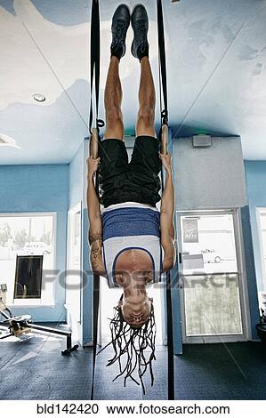 Stock Image - Asian man exercising in gym. Fotosearch
