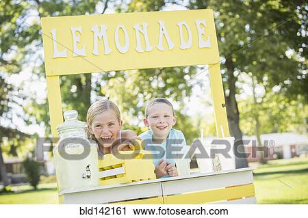 Stock Image - Caucasian brother and sister smiling at lemonade stand. Fotosearch