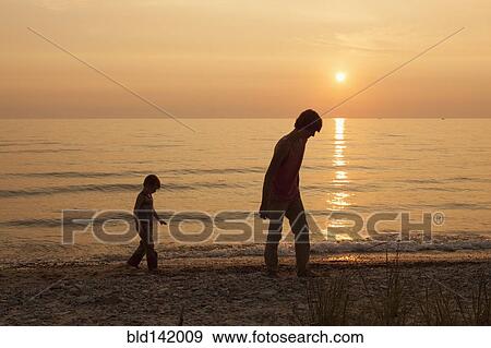 Caucasian brothers walking on beach at sunset View Large Photo Image Stock Photo - Caucasian brothers walking on beach at sunset. Fotosearch