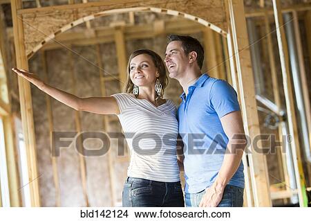 Caucasian couple admiring house under construction View Large Photo Image Picture - Caucasian couple admiring house under construction. Fotosearch