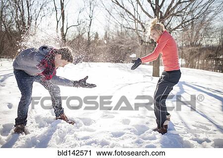 Stock Image - Caucasian couple having snowball fight. Fotosearch