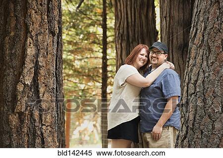 Stock Photography - Caucasian couple hugging in forest. Fotosearch