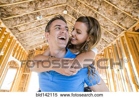 Caucasian couple hugging in house under construction View Large Photo Image Stock Photography - Caucasian couple hugging in house under construction. Fotosearch