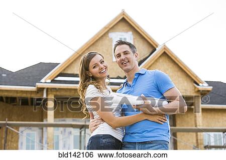 Caucasian couple hugging near house under construction View Large Photo Image Stock Photograph - Caucasian couple hugging near house under construction. Fotosearch