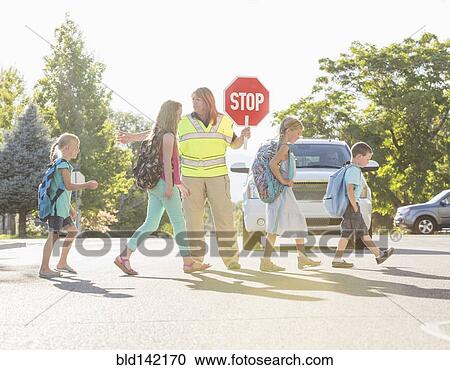 Caucasian crossing guard helping children in crosswalk View Large Photo Image Stock Image - Caucasian crossing guard helping children in crosswalk. Fotosearch