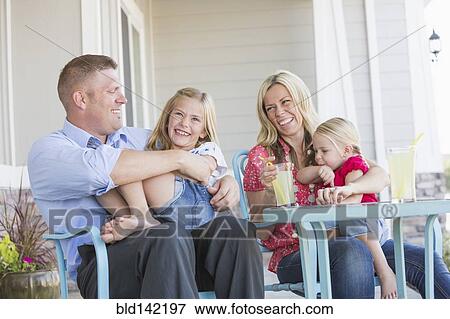 Stock Photo - Caucasian family sitting on porch. Fotosearch