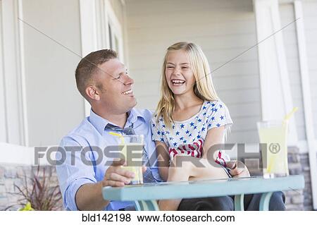 Stock Photo - Caucasian father and daughter laughing on porch. Fotosearch
