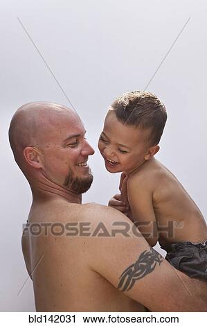 Stock Image - Caucasian father holding son. Fotosearch