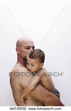 Stock Image - Caucasian father holding son. Fotosearch