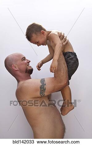 Stock Image - Caucasian father holding son. Fotosearch