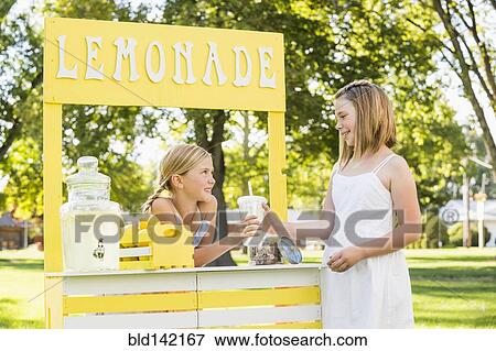 Stock Photo - Caucasian girl buying drink at lemonade stand. Fotosearch