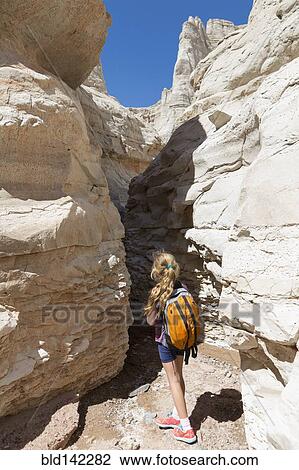 Stock Image - Caucasian girl exploring rock formations. Fotosearch