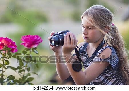 Caucasian girl photographing flowers outdoors View Large Photo Image Picture - Caucasian girl photographing flowers outdoors. Fotosearch