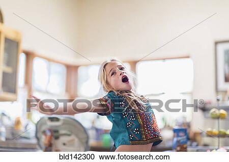 Stock Image - Caucasian girl singing indoors. Fotosearch