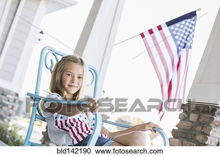 Caucasian girl sitting on porch near American flag View Large Photo Image Stock Image - Caucasian girl sitting on porch near American flag. Fotosearch