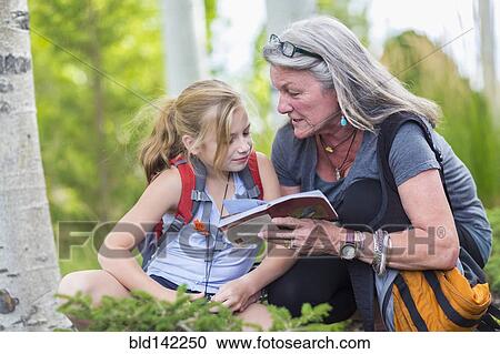 Caucasian grandmother and granddaughter reading guidebook while hiking View Large Photo Image Stock Image - Caucasian grandmother and granddaughter reading guidebook while hiking. Fotosearch
