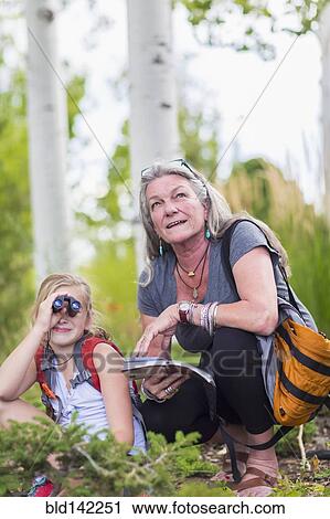 Caucasian grandmother and granddaughter using binoculars while hiking View Large Photo Image Stock Image - Caucasian grandmother and granddaughter using binoculars while hiking. Fotosearch
