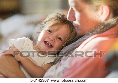 Caucasian mother and baby son cuddling on sofa View Large Photo Image Stock Photo - Caucasian mother and baby son cuddling on sofa. Fotosearch