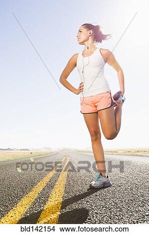 Caucasian runner stretching on remote road View Large Photo Image Picture - Caucasian runner stretching on remote road. Fotosearch