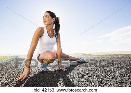 Caucasian runner stretching on remote road View Large Photo Image Stock Image - Caucasian runner stretching on remote road. Fotosearch